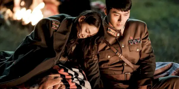 Yoon Se Ri and Ri Jeong Hyeok from Crash Landing On You sitting near a bonfire