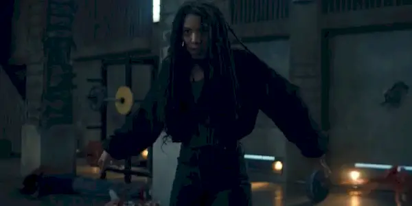 Jaz Sinclair as Marie Moreau, standing center frame with her arms outstretched and preparing to attack, in a shot from 