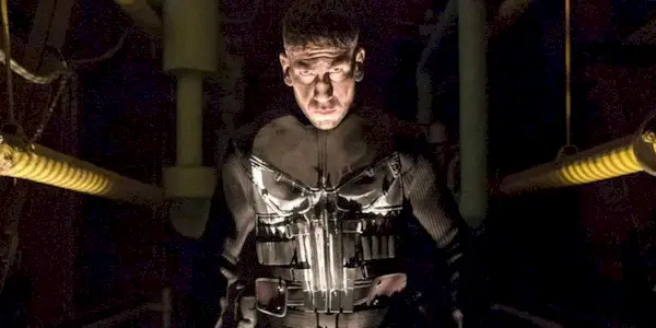 The Punisher in a dark hallway looking at the camera.