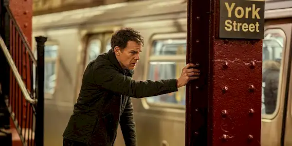 Dexter leaning against a subway column in Dexter: Resurrection.