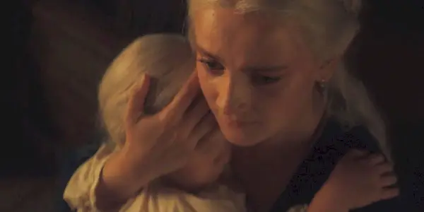 Phia Saban as Helaena cradling her daughter Jaehaera in her arms in House of the Dragon Season 2 Episode 1