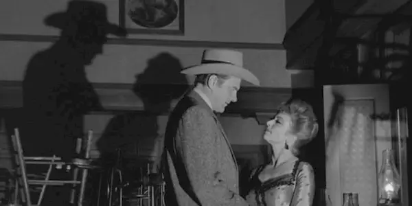 Marshal Matt Dillon (James Arness) looks down at Miss Kitty (Amanda Blake) as their shadows bounce on the wall on 