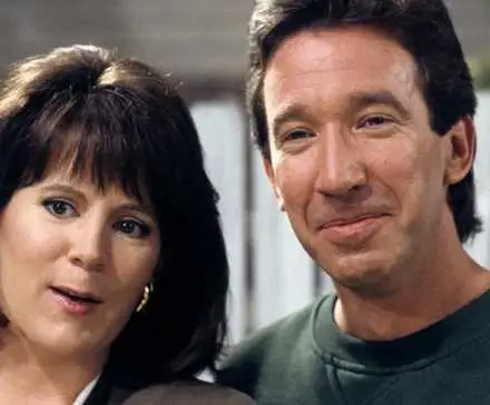 Patricia Richardson and Tim Allen standing in front of a white fence in Home Improvement