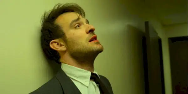 Matt leaning against a prison wall in Daredevil.