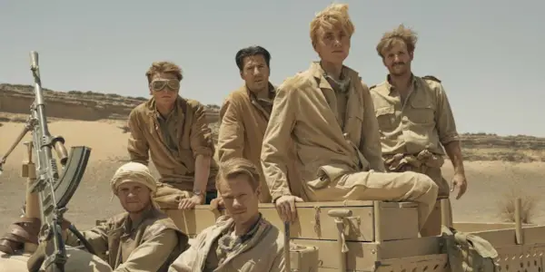 Soldiers sit in a vehicle in khaki desert fatigues in SAS Rogue Heroes.