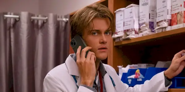 Conrad Fisher talking on the phone while working in a lab and wearing a medical jacket in The Summer I Turned Pretty TSITP Season 3