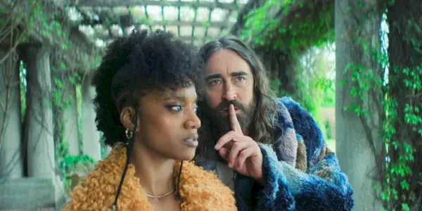 Day, finger raised to his lips in a quiet gesture, hiding behind Song in Foundation Season 3 Episode 3