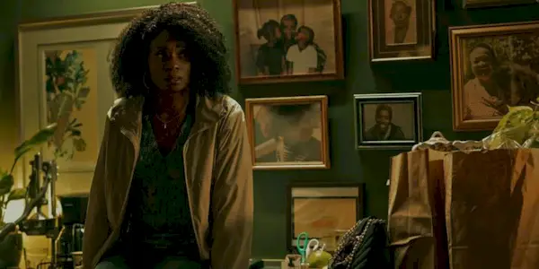 Adina Porter sitting on a kitchen counter looking scared in Smoke