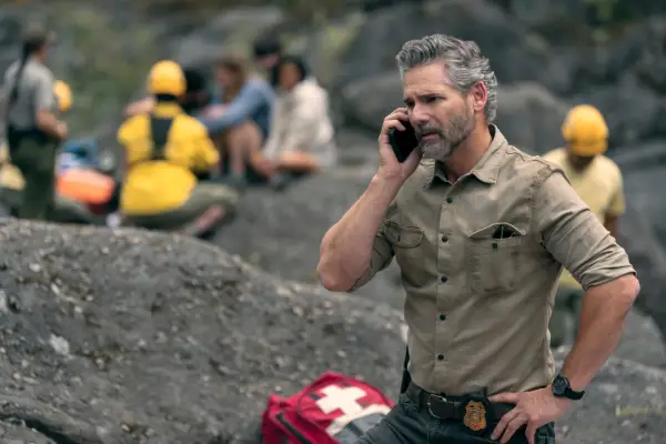 Eric Bana as Kyle Turner in Untamed., stood amongst rubble and speaking on the phone