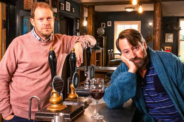 David Mitchell and Robert Webb in Back. Webb is stood behind the bar at a pub and Mitchell is sat the other side with his head in his hand.