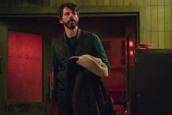 Matthew Goode in Dept Q holding his jacket