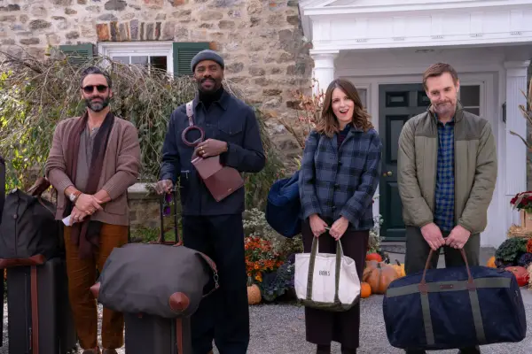 (L-R) Marco Calvani as Claude, Colman Domingo as Danny, Tina Fey as Kate, and Will Forte as Jack in The Four Seasons, standing in front of a large house holding luggage