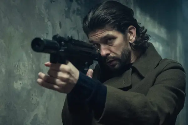 Ben Whishaw as Sam Young looking down the barrel of a gun