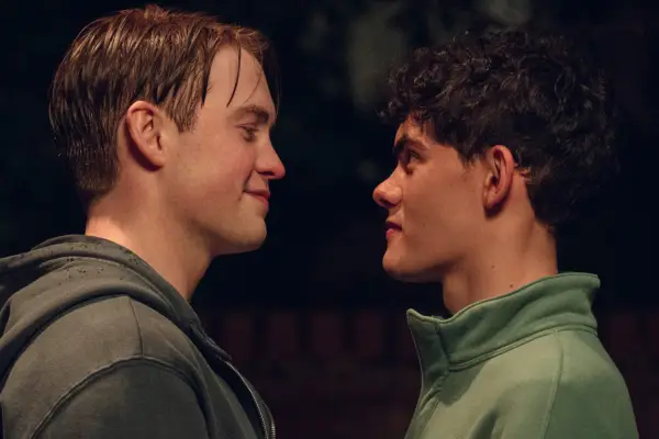 Nick Nelson and Charlie Spring standing close together and smiling at each other