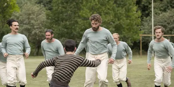 Men playing football in The English Game.