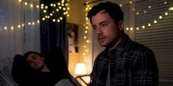 Zeke from Manifest teary-eyed, sitting at the foot of Cal