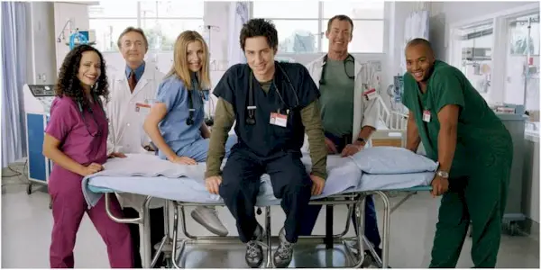 The cast of Scrubs smiling in a promotional image