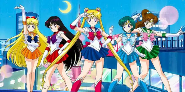 The main characters from Sailor Moon posing with a city at night in the background.